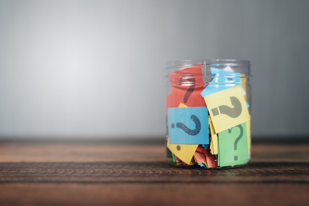 Question marks printed on multi-colored paper inside mason jar